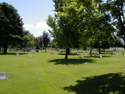 a grassy field that includes cemetery headstones.